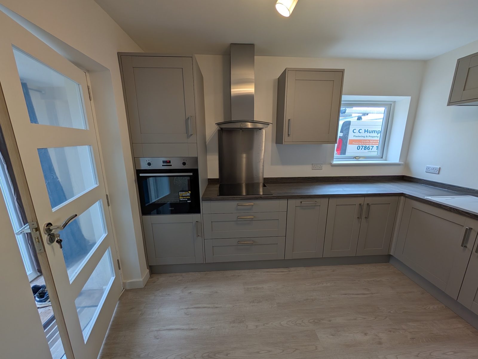 Finished kitchen with grey shaker units, our van outside the window