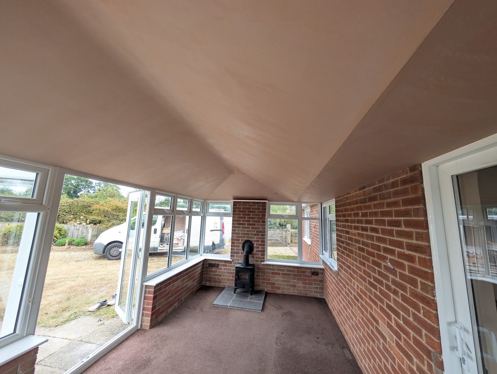 Orangery with a new ceiling boarded and skimmed, brick walls and a wood burner