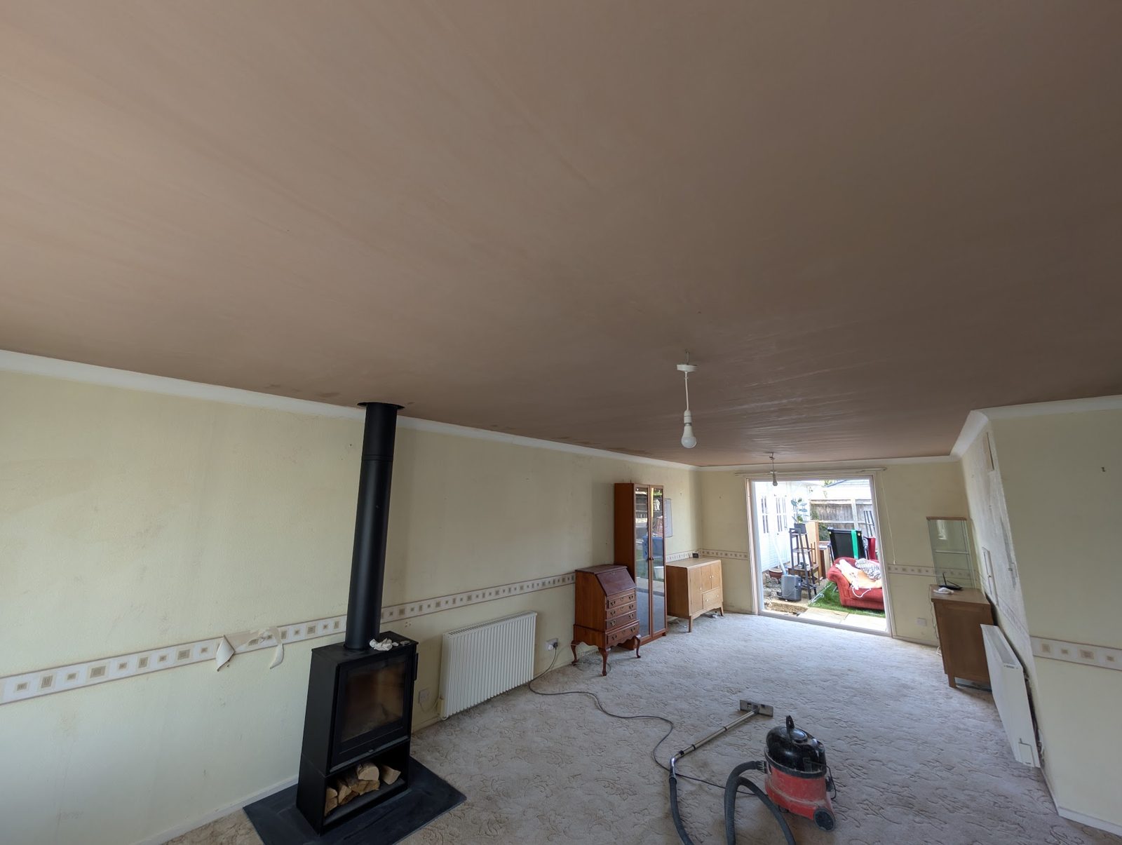Lounge with a wood burner and a newly skimmed ceiling