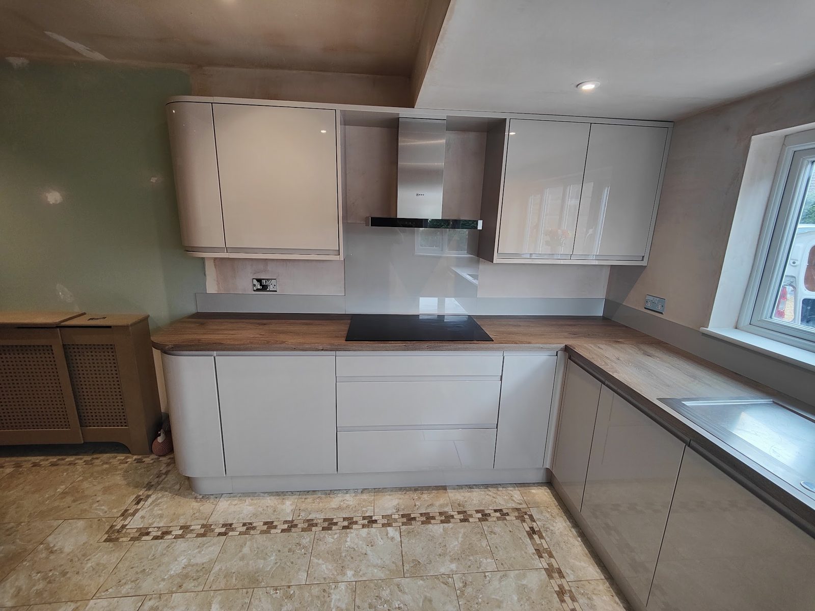 Cream gloss kitchen with a patterned tiled floor