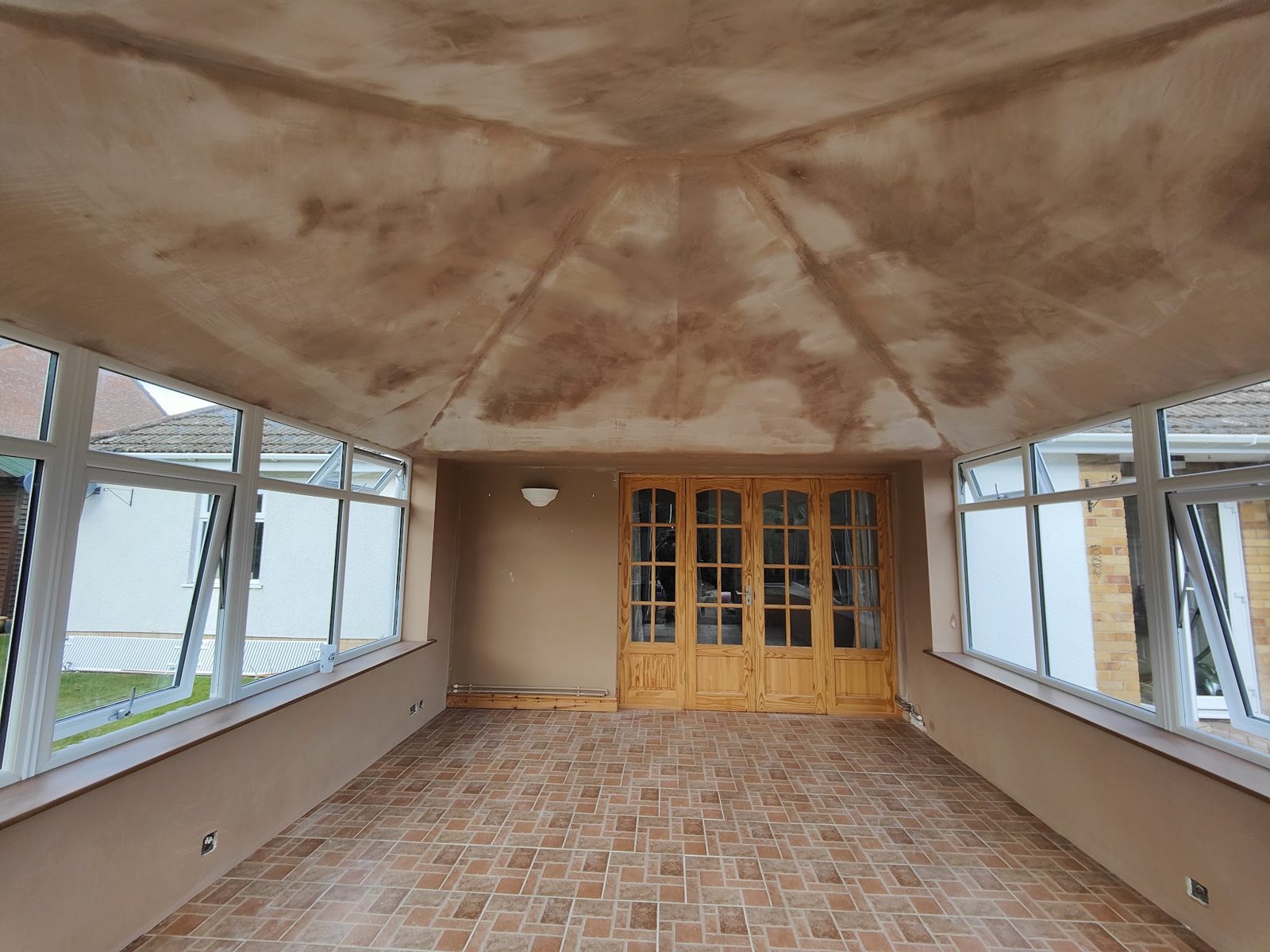 Conservatory with a plastered ceiling and walls, tiled floor