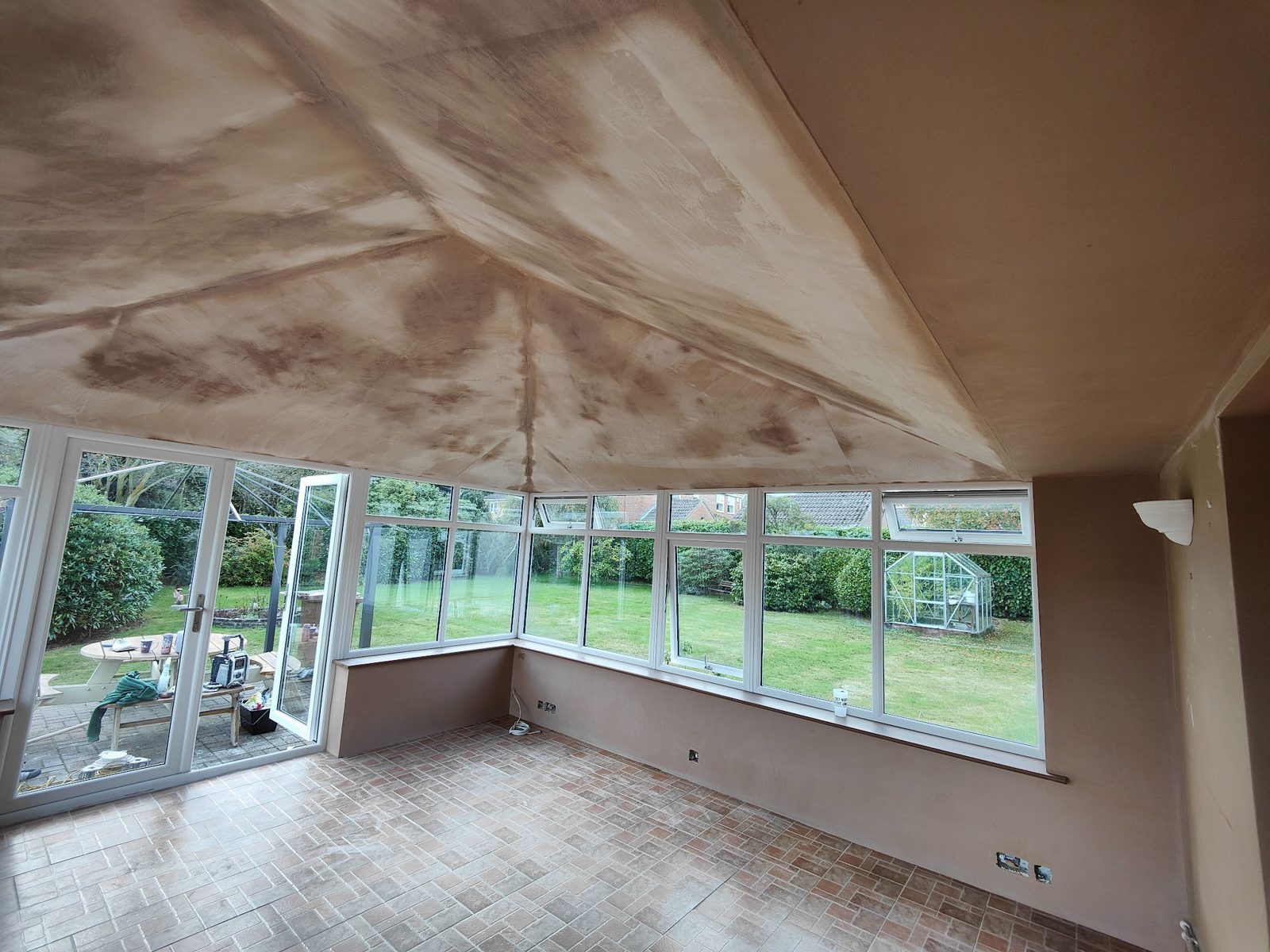 Conservatory ceiling plastered, garden beyond the windows
